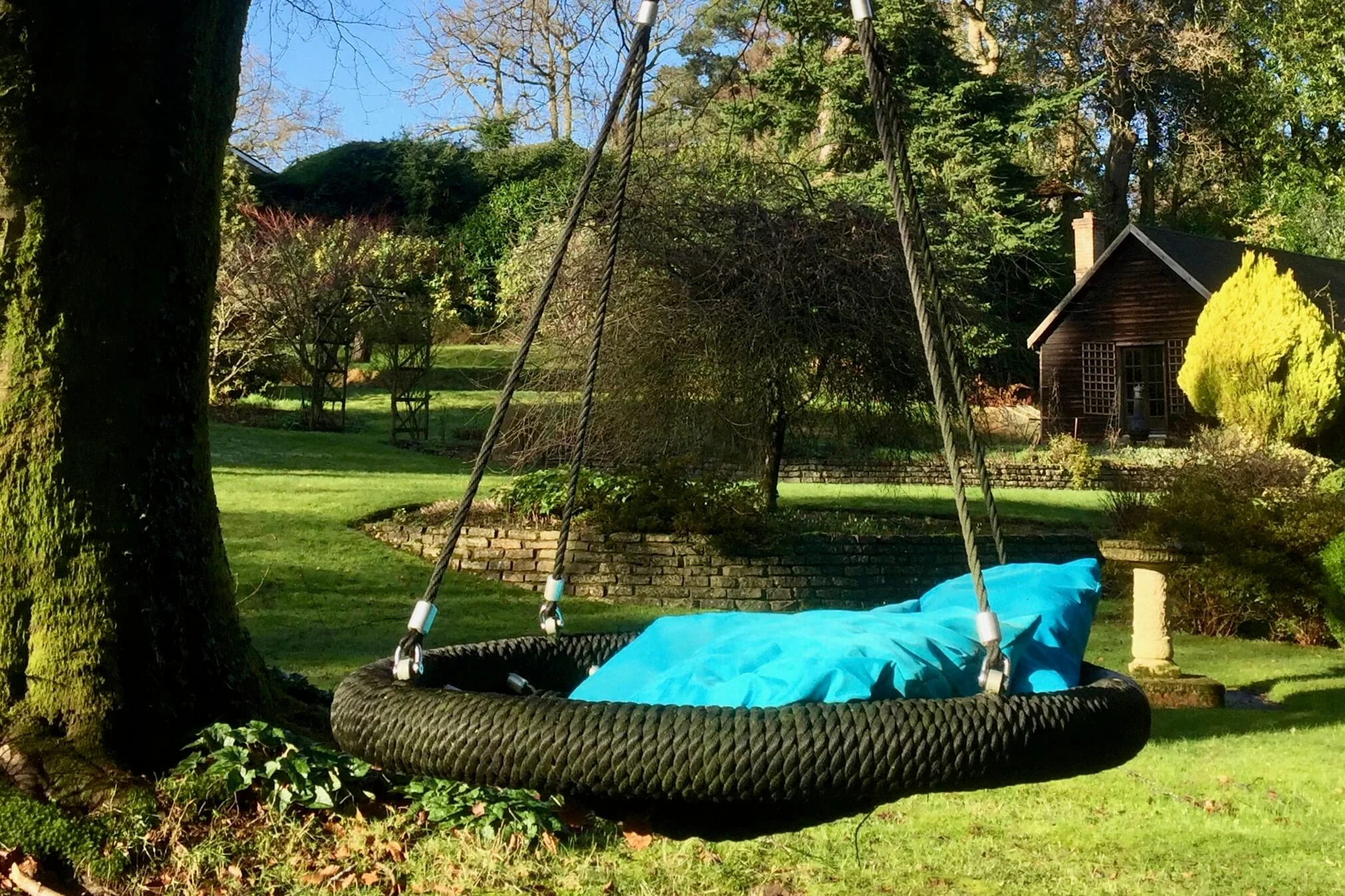 Nest Swing and blue cushions in garden