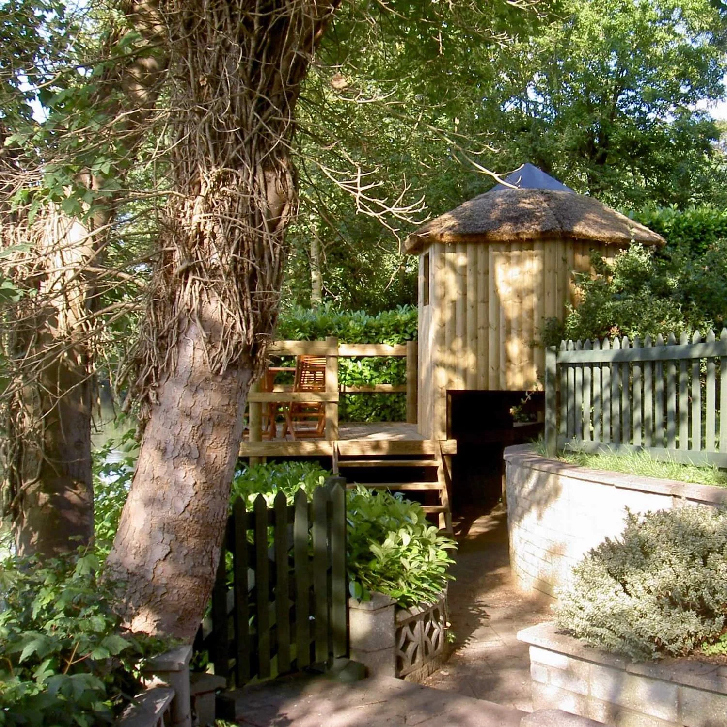 "...treehouse and deck set into garden"