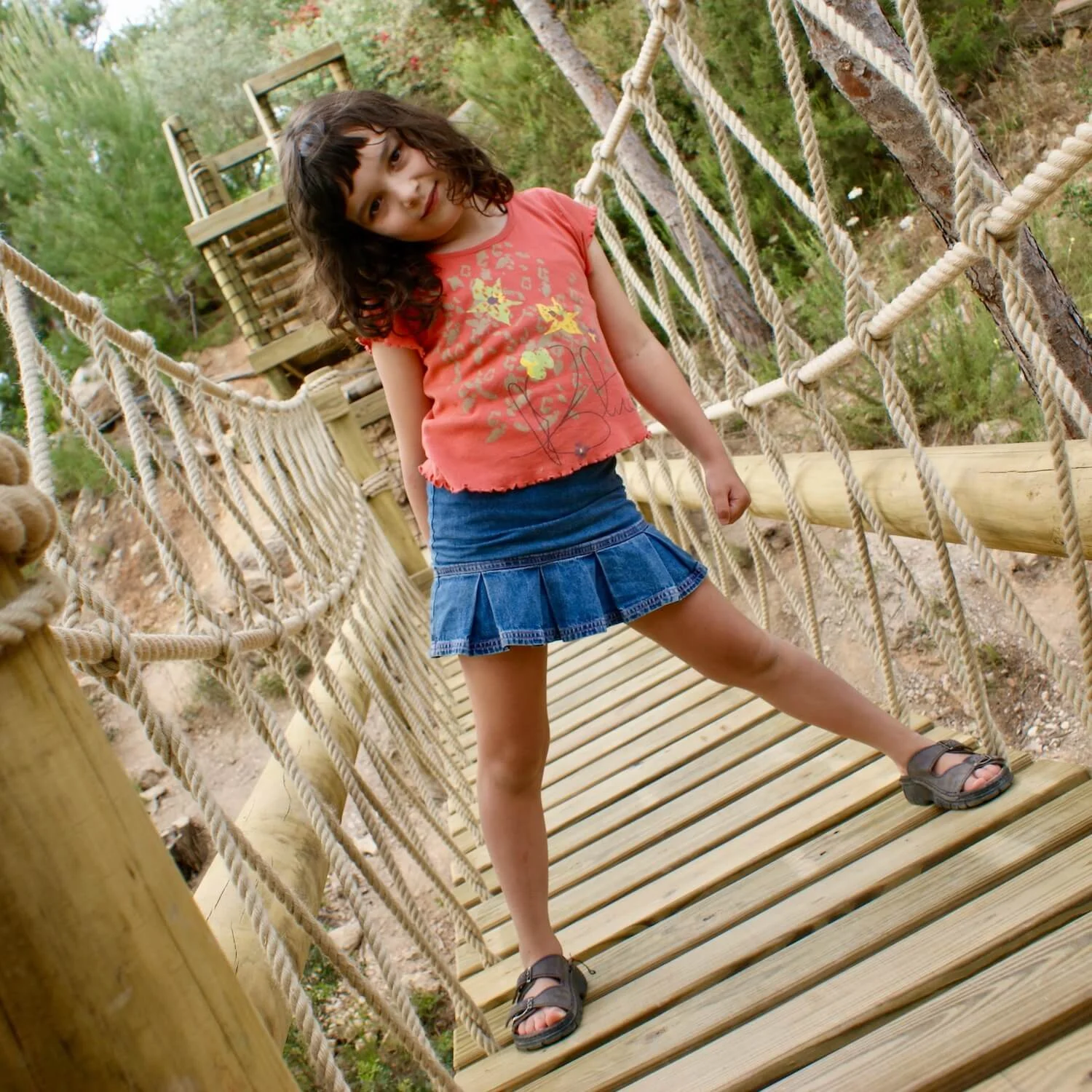 "...girl playing on rope bridge"