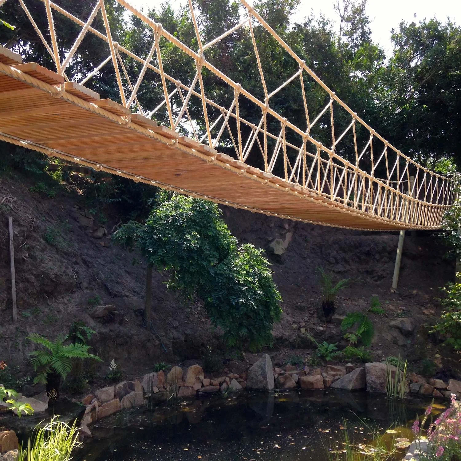 "...rope bridge over a garden lake"