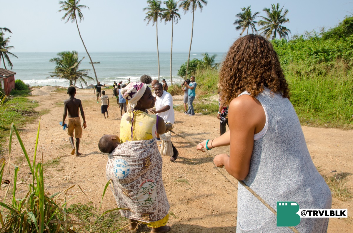 A stop roadside to help locals pull a large net of fish out of the water. Photo credit: Kumi Rauf, Traveling Black