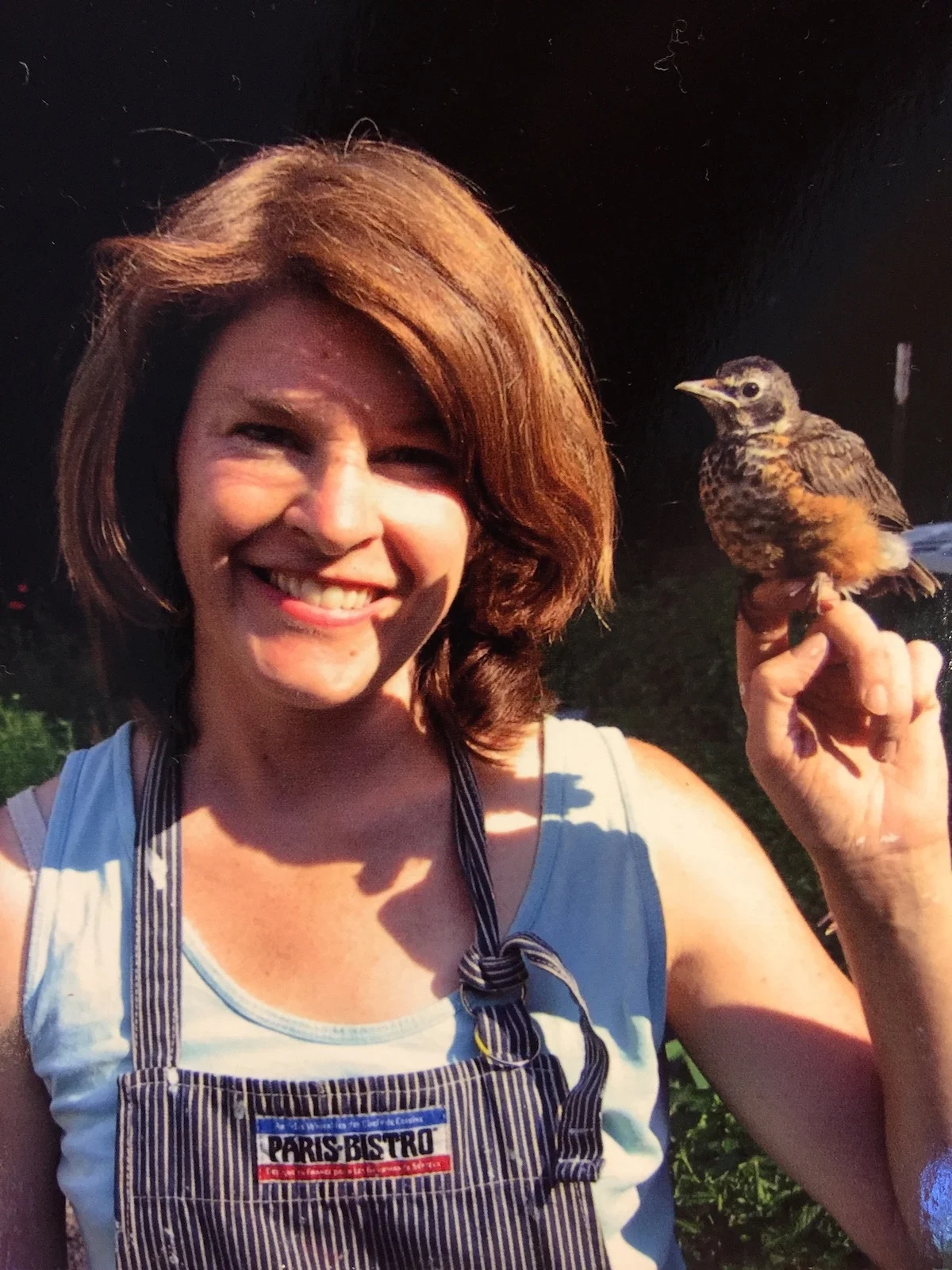 Me with Bird, a robin I raised when it fell from a nest. I taught him how to dig for worms and when you put your hand in the air, he would fly to you. It migrated about a month after this photo was taken.