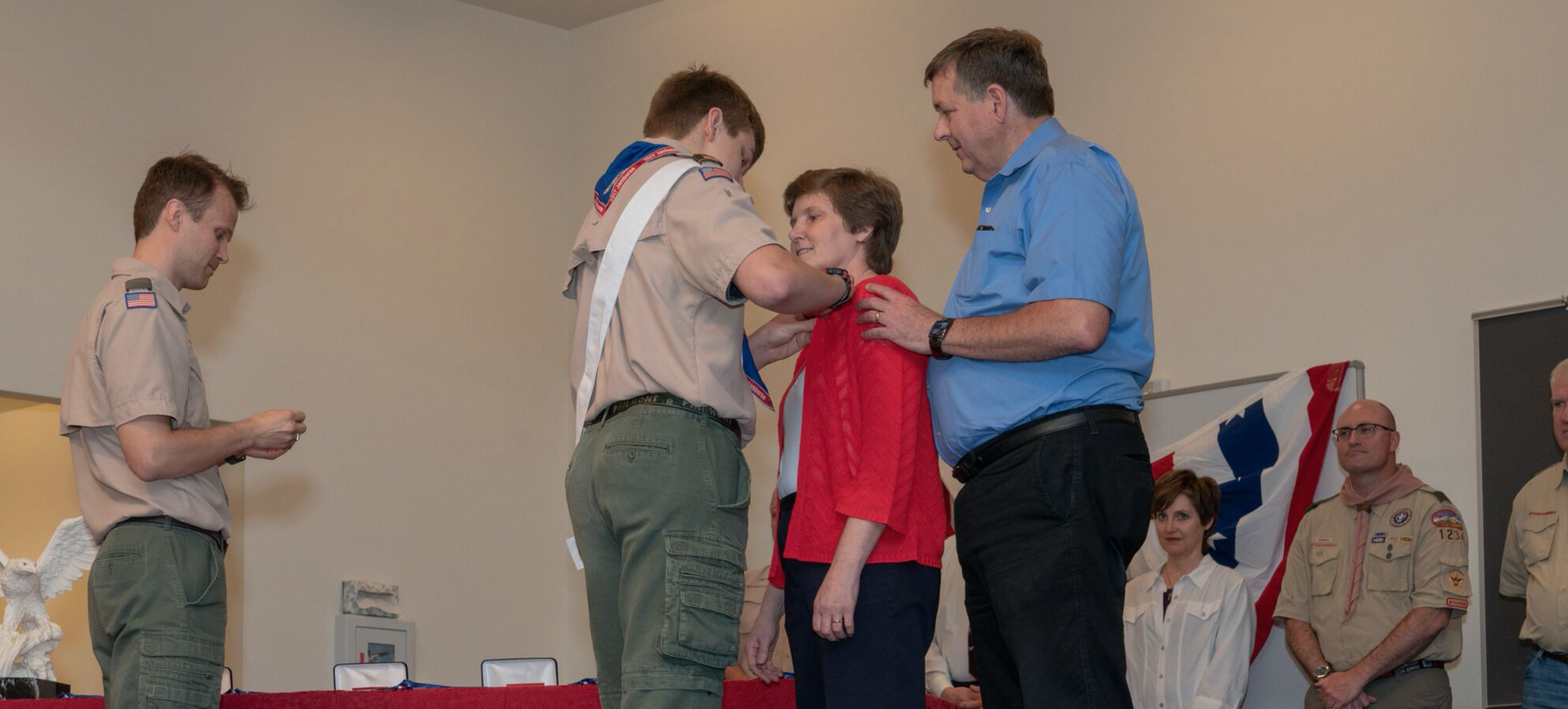 Jared Grimes affixes Eagle Scout parent pin to his mom