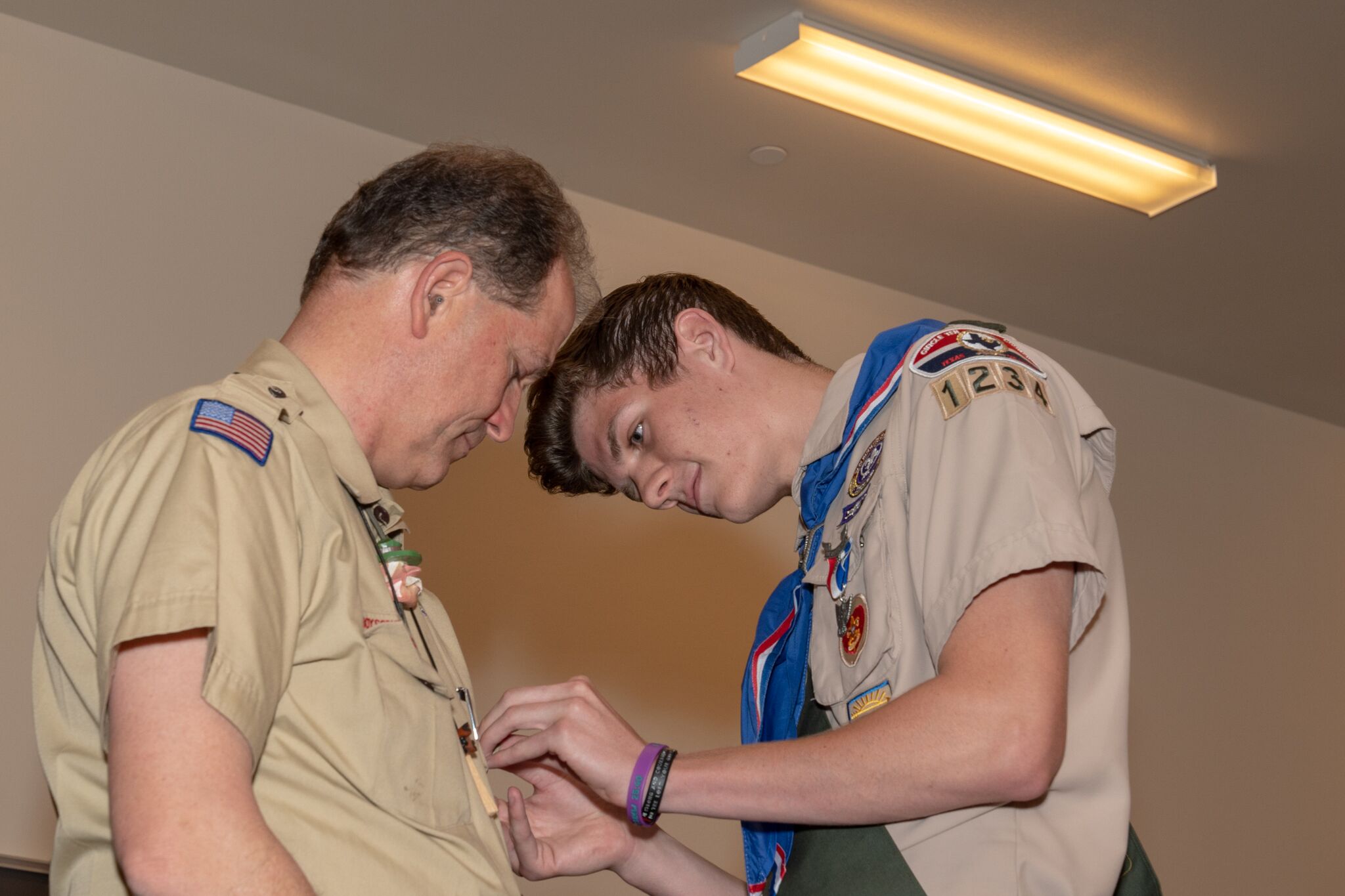 Cody Larimer pins Scoutmaster Mike Fisher with an Eagle Scout Mentor pin, one of four Fisher received during the Court of Honor ceremonies