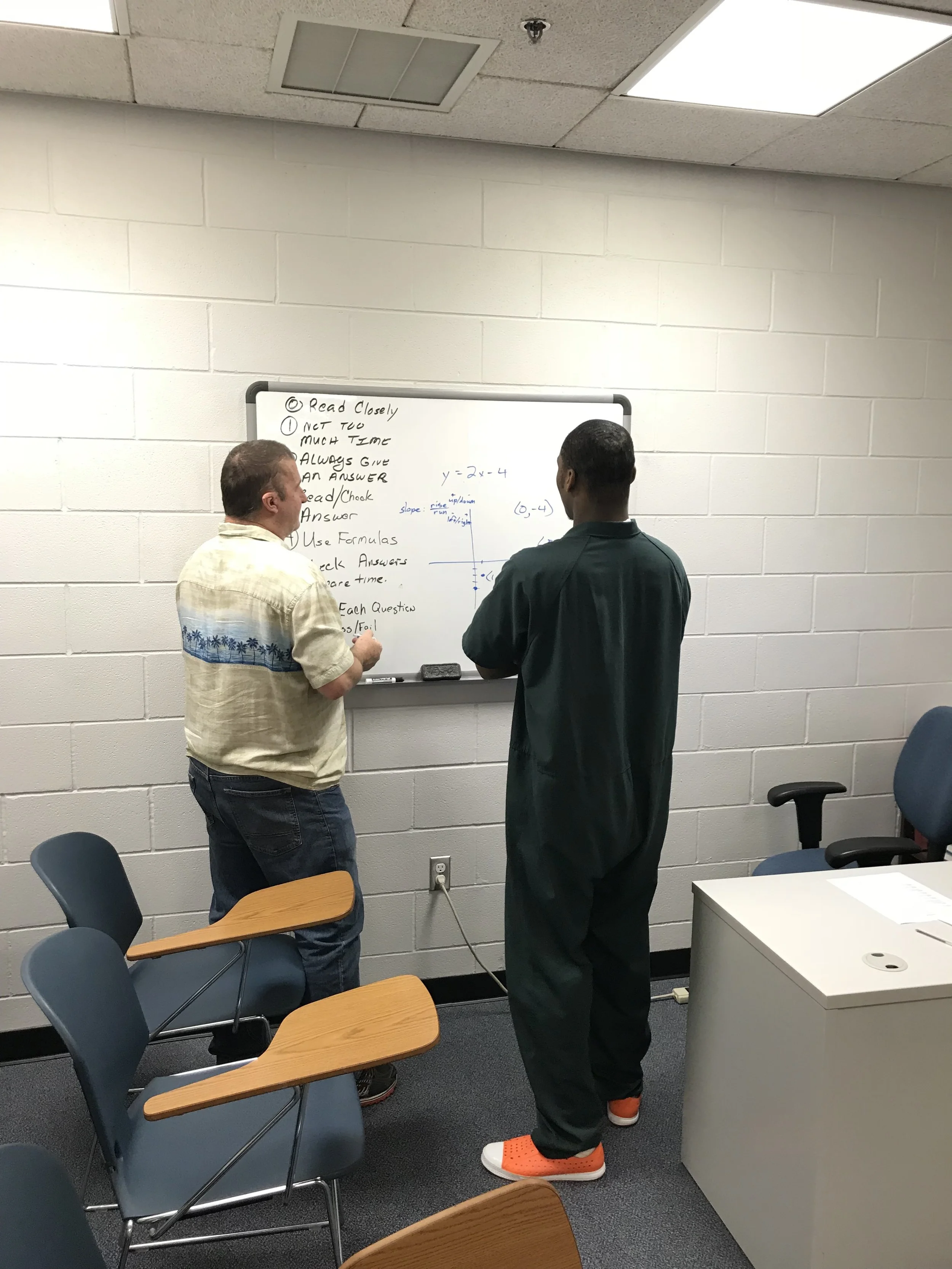 Photos provided by CCSO. Inmate with a volunteer math tutor during a GED class.