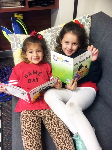 Solenne Vela and Nora Price enjoying books from the Literacy Library