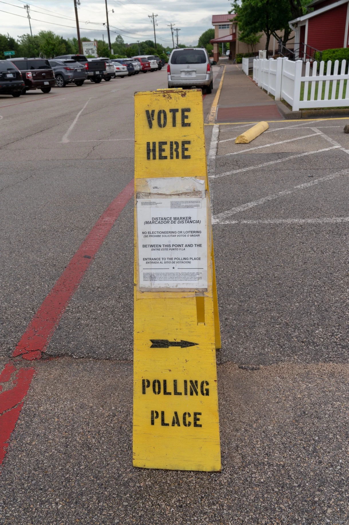 Election judges and their clerks prepare the inside and outside of polling places to conform exactly to election law. In the case of this parking lot marker, it delineates the “no cross” line beyond which electioneering is prohibited.