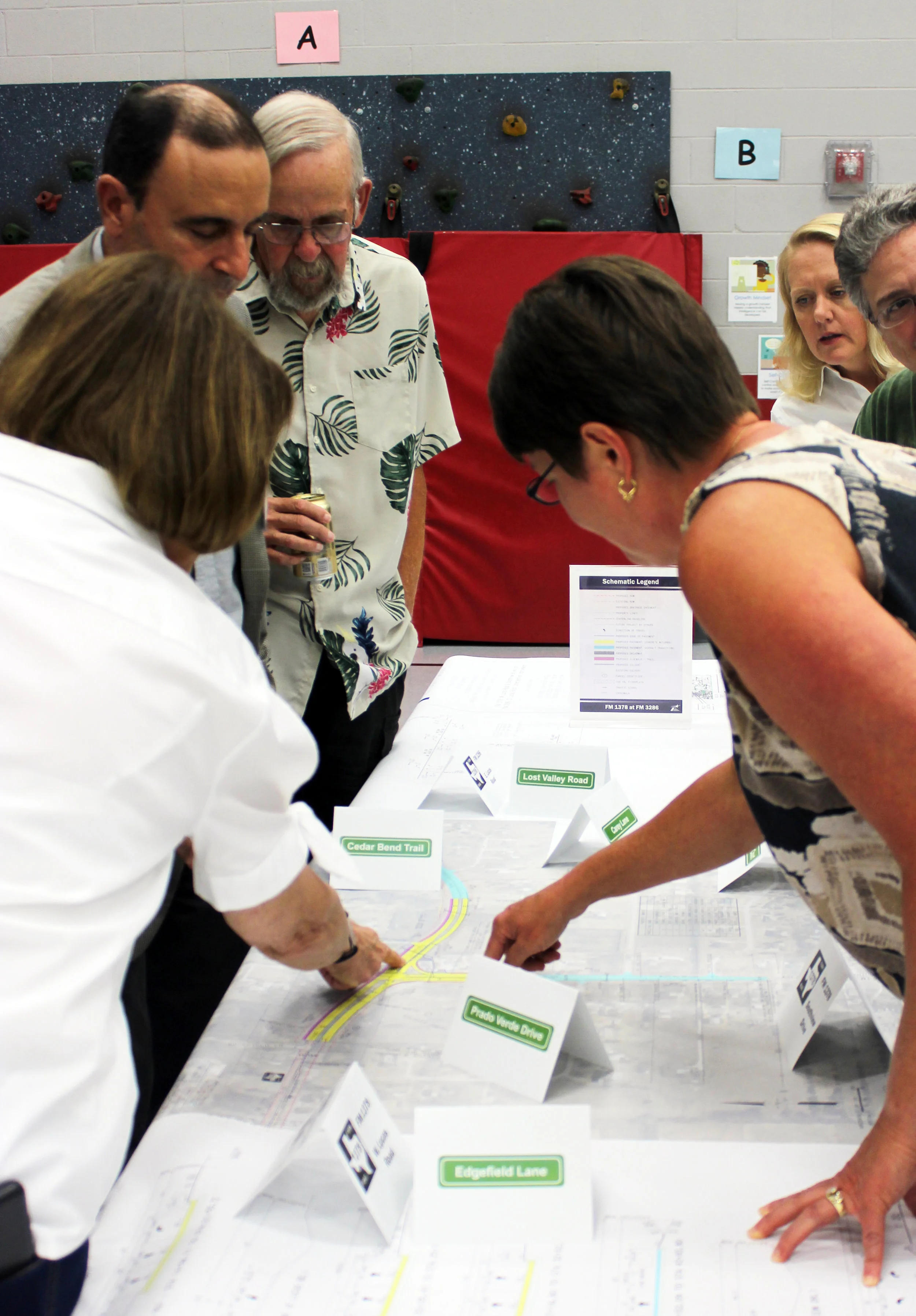 Multiple tables with schematics were set up in the gym of Lovejoy Elementary School. TxDOT engineers fielded questions and listened to concerns regarding the proposed intersection improvements.