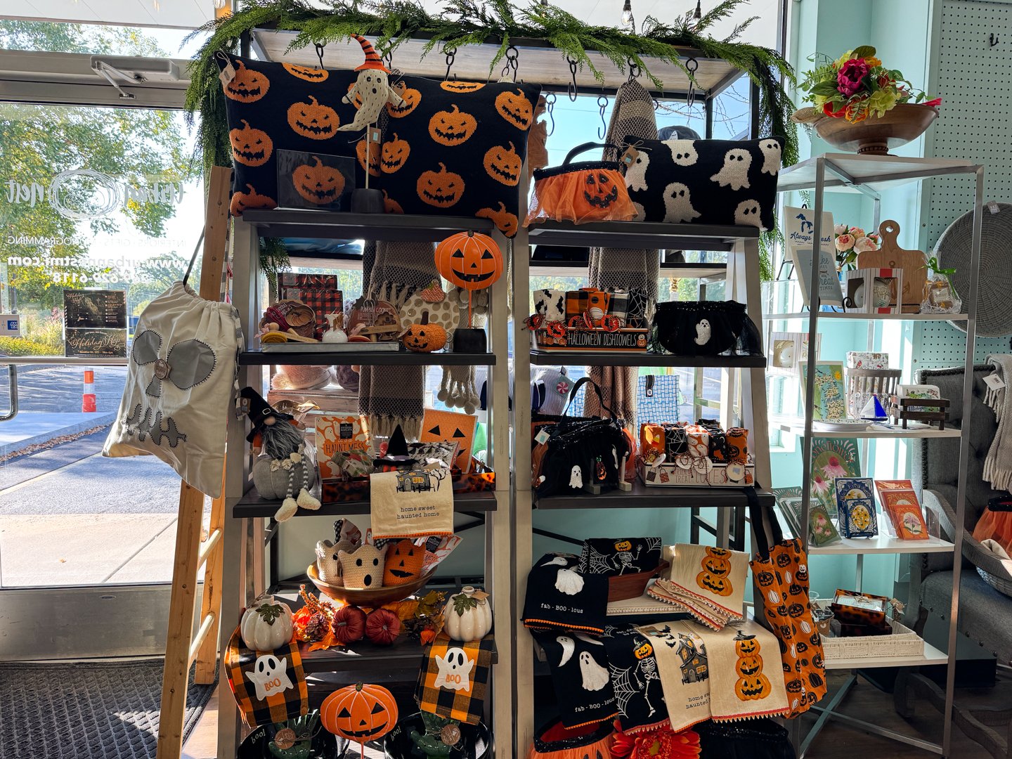 Halloween display with ghost-themed pillows, pumpkin decor, and handcrafted autumn gifts