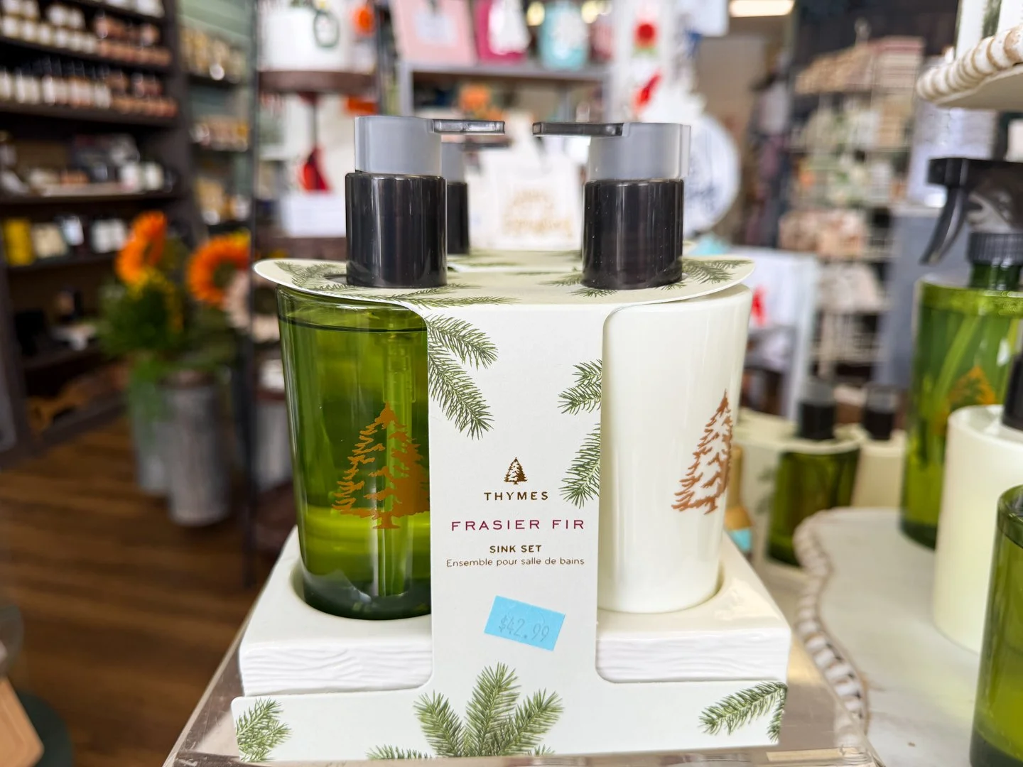 Thymes Frasier Fir soap and lotion sink set in a white ceramic caddy with green pine tree illustrations