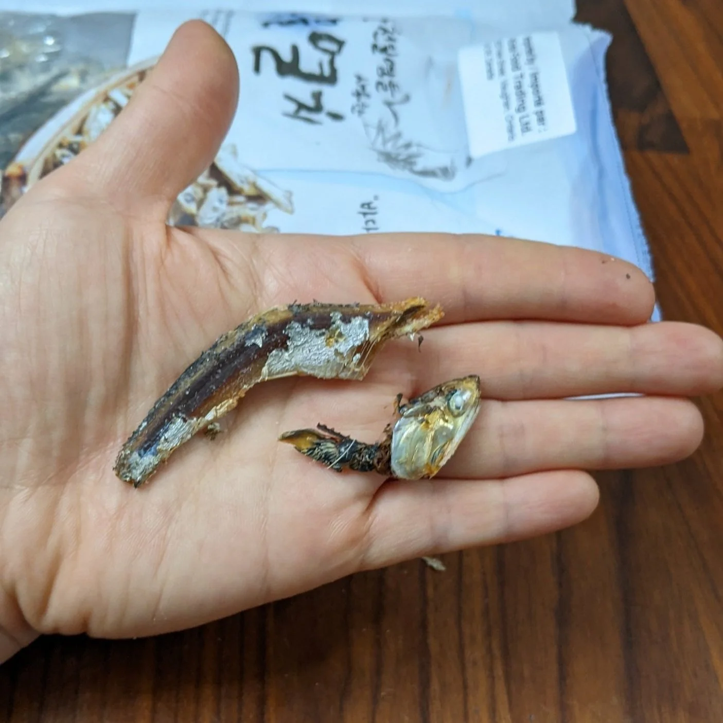  Gutting dried anchovies by pinching belly and removing the guts (black stuff).  You can remove heads too if you like. 