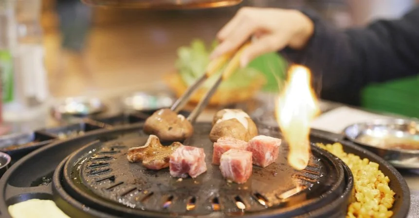 Pork Belly and mushrooms on a Korean BBQ tabletop grill.