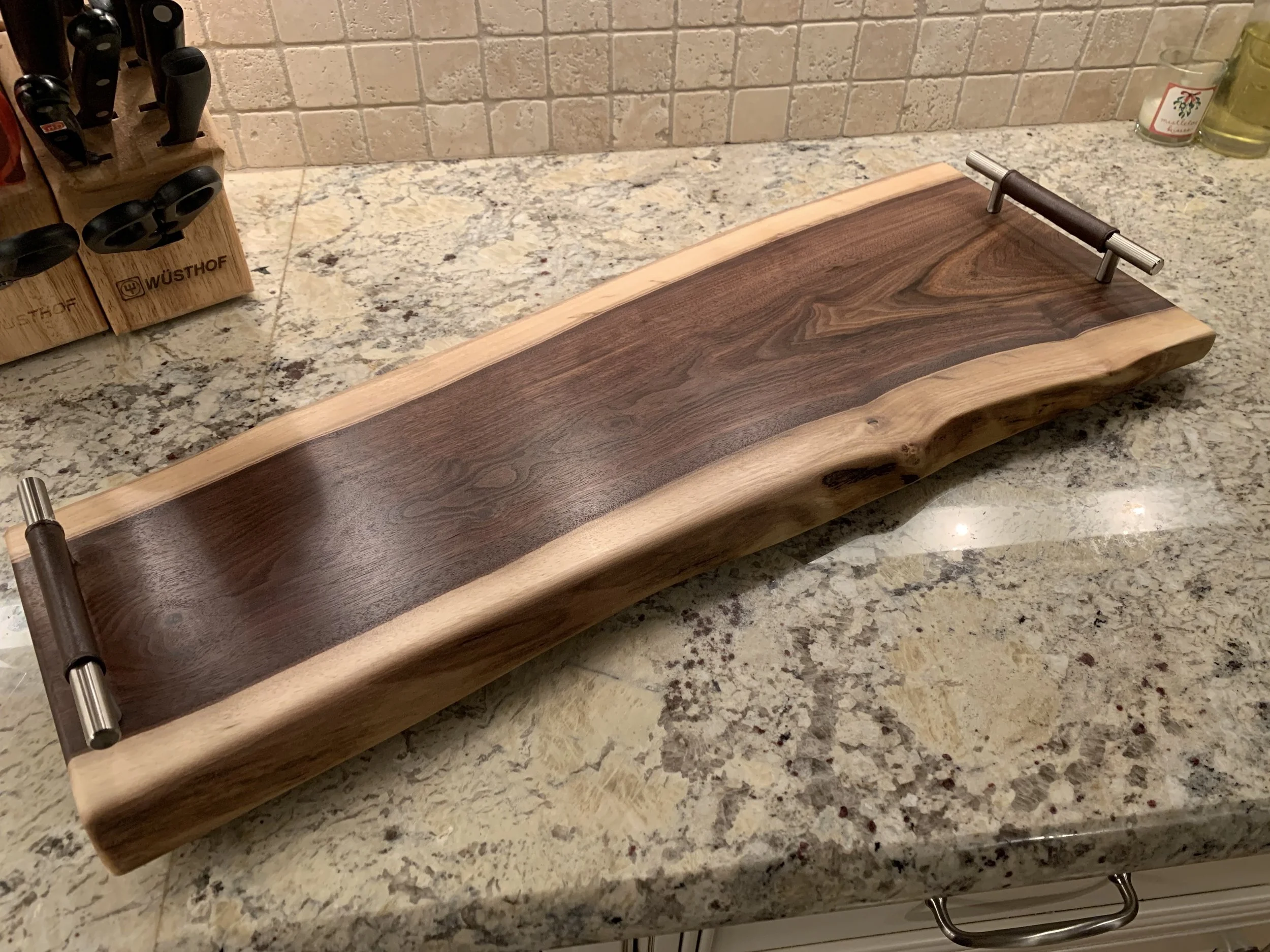 Live Edge walnut serving board with leather wrapped handles (30 inches long). Handmade in Madison, Connecticut.