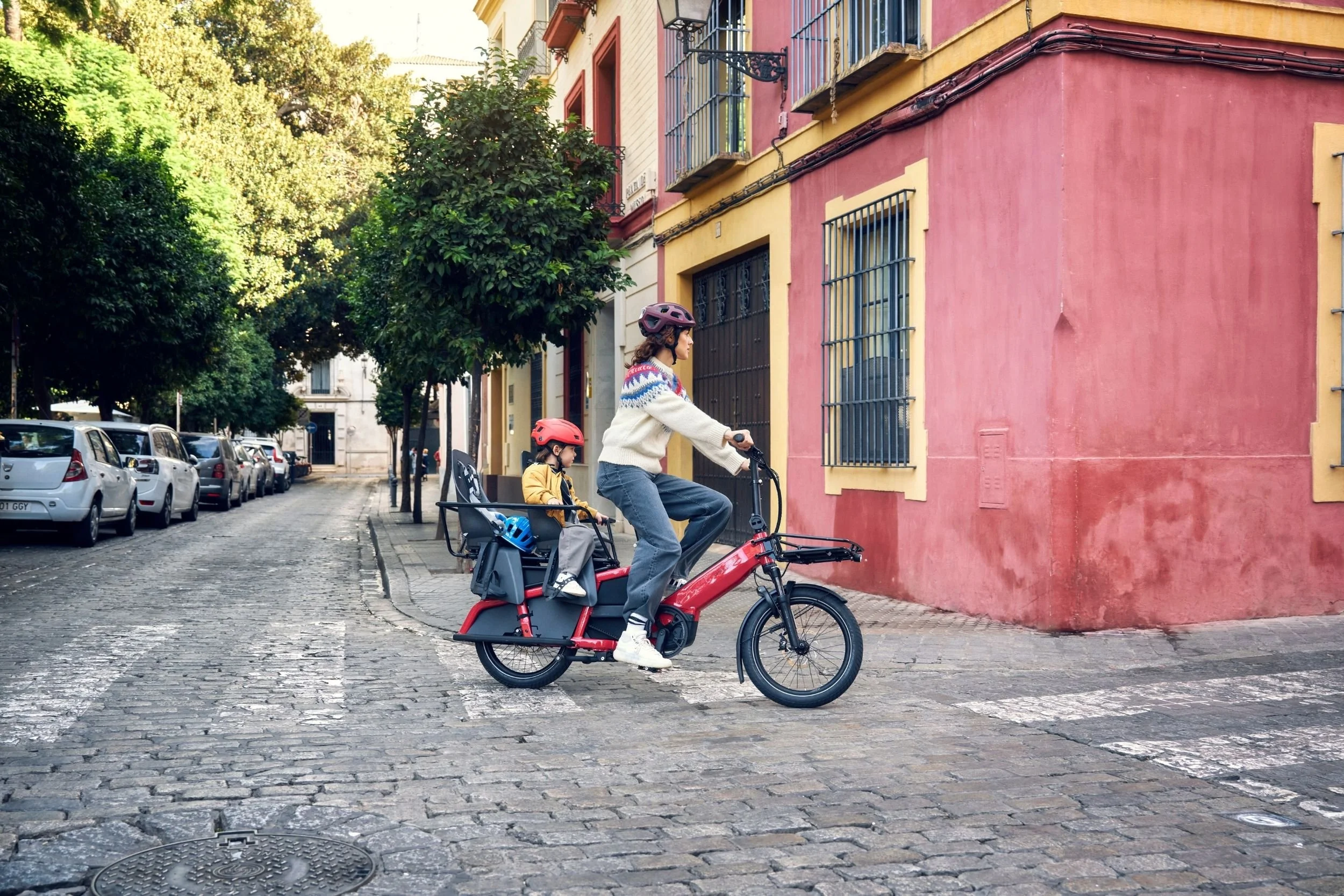 mom and son riding a cargo bike through the city