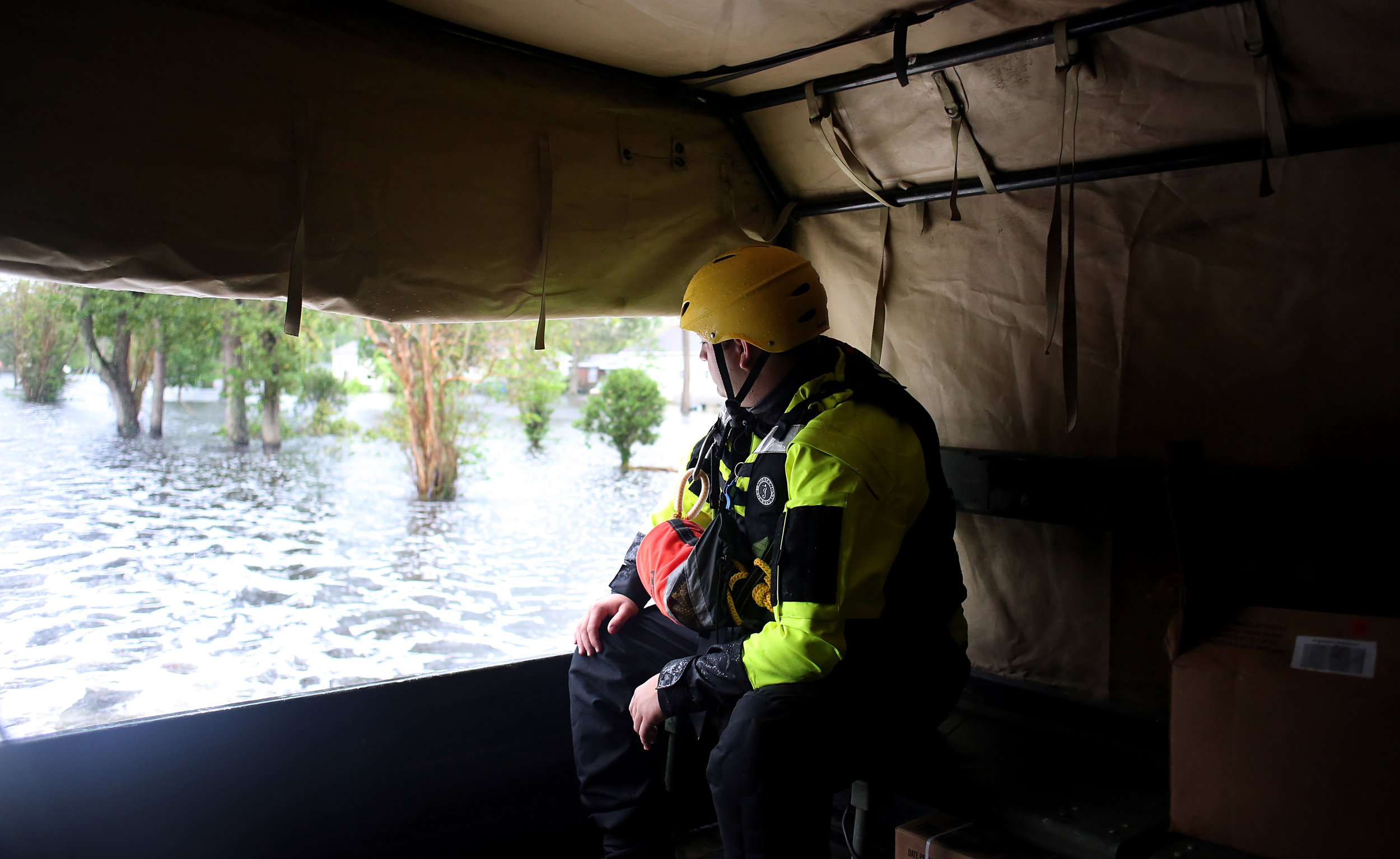 A member of North Carolina Task Force 10 looks out at floodwaters from the back of a national guard LMTV as a mixed unit of guardsmen and rescue personnel conducted welfare checks, Sept. 15 in New Bern, N.C.