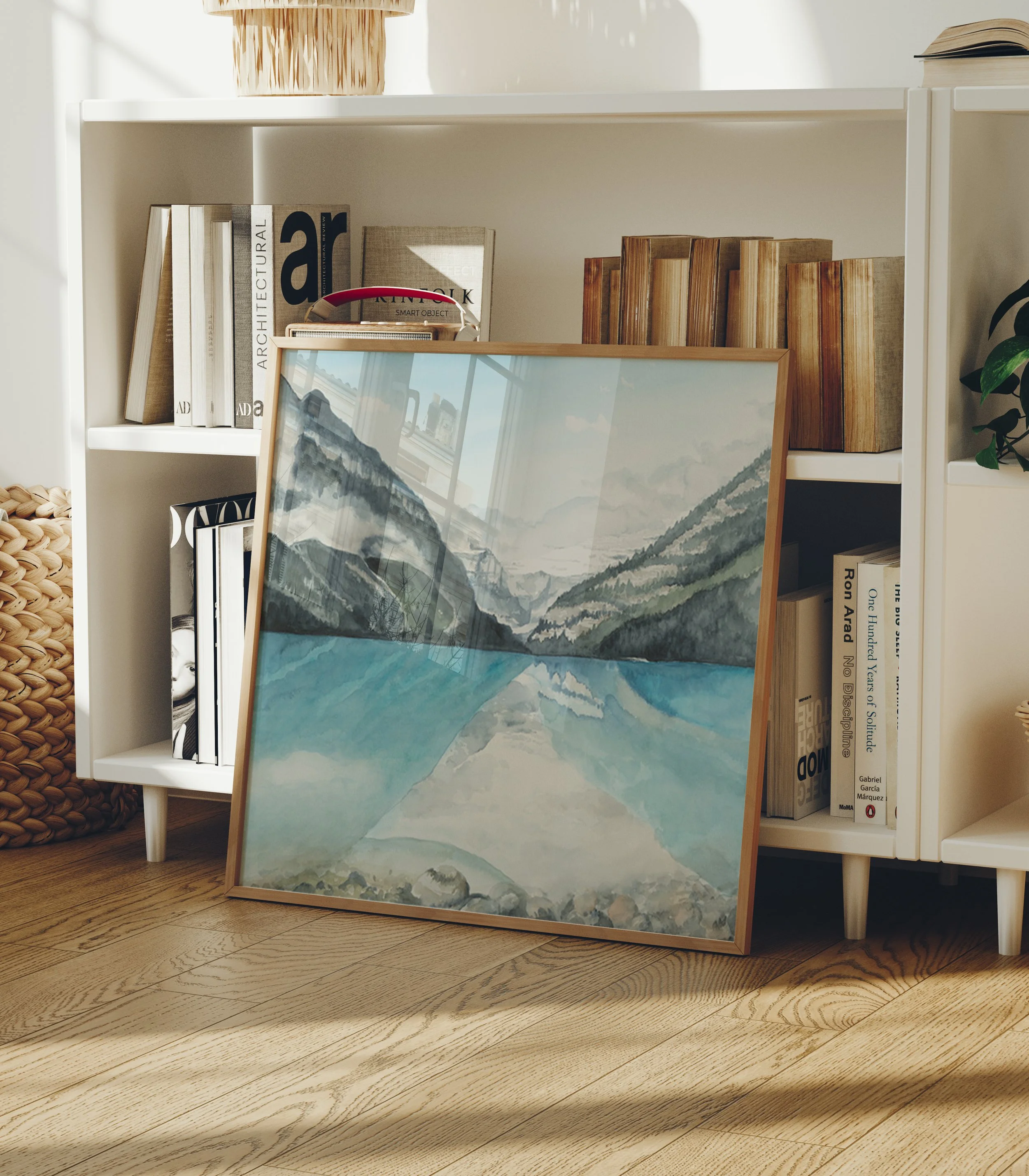 Lake Louise Canadian Rocky Mountain watercolor landscape wall art print. Banff National Park, Alberta turquoise glacier lake nature inspired giclee art leaning against a book shelf