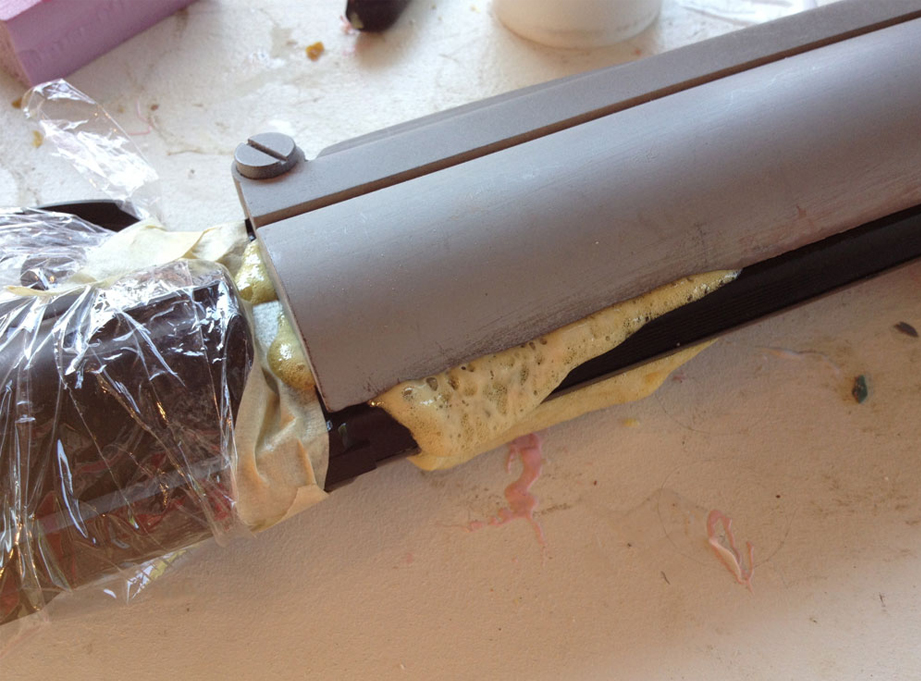  I covered the gun in plastic wrap, poured some expanding foam into the cavity and then seated the gun. The foam expanded and filled the inner space. 