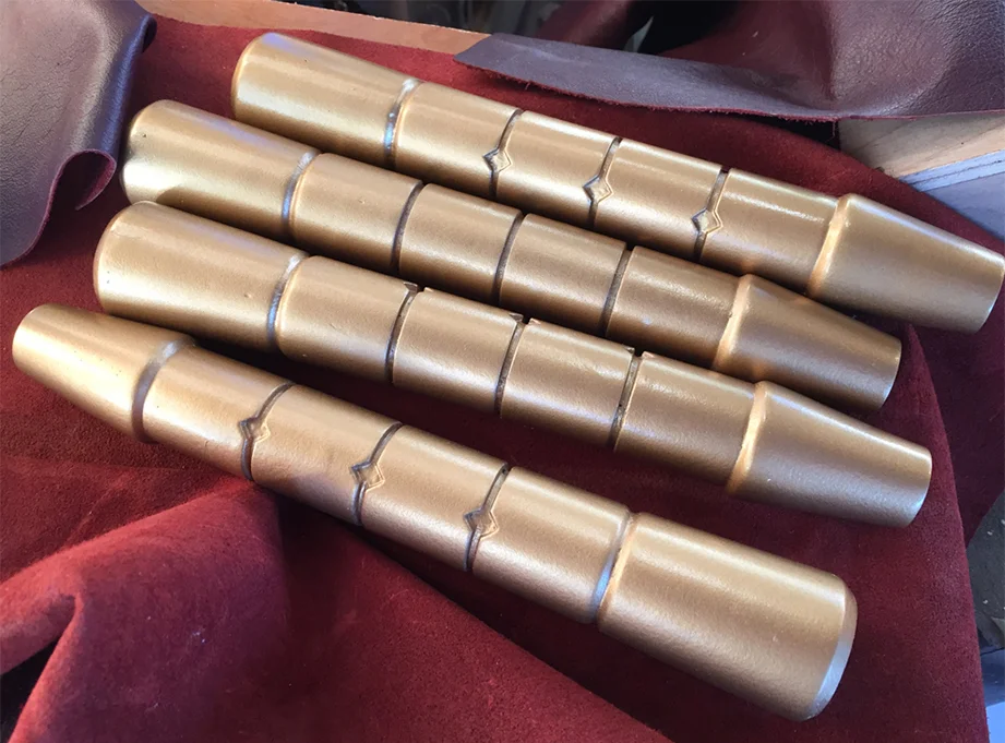 I made a mold from the master and cast resin copies. They were then painted gold.