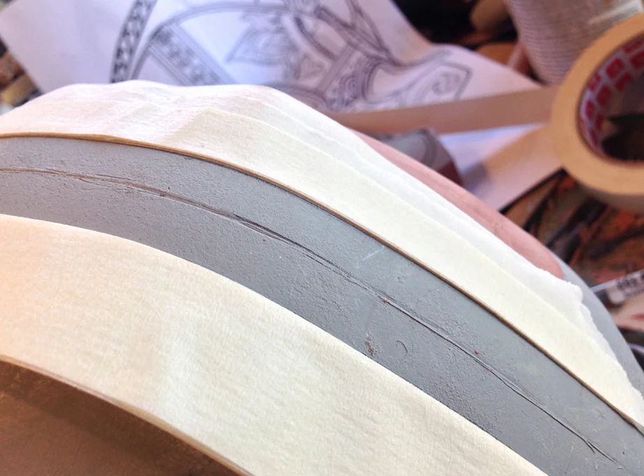 To make the raised bands that run down from the top of the helmet, I stacked up nine layers of masking tape and placed them on either side of the band areas.
