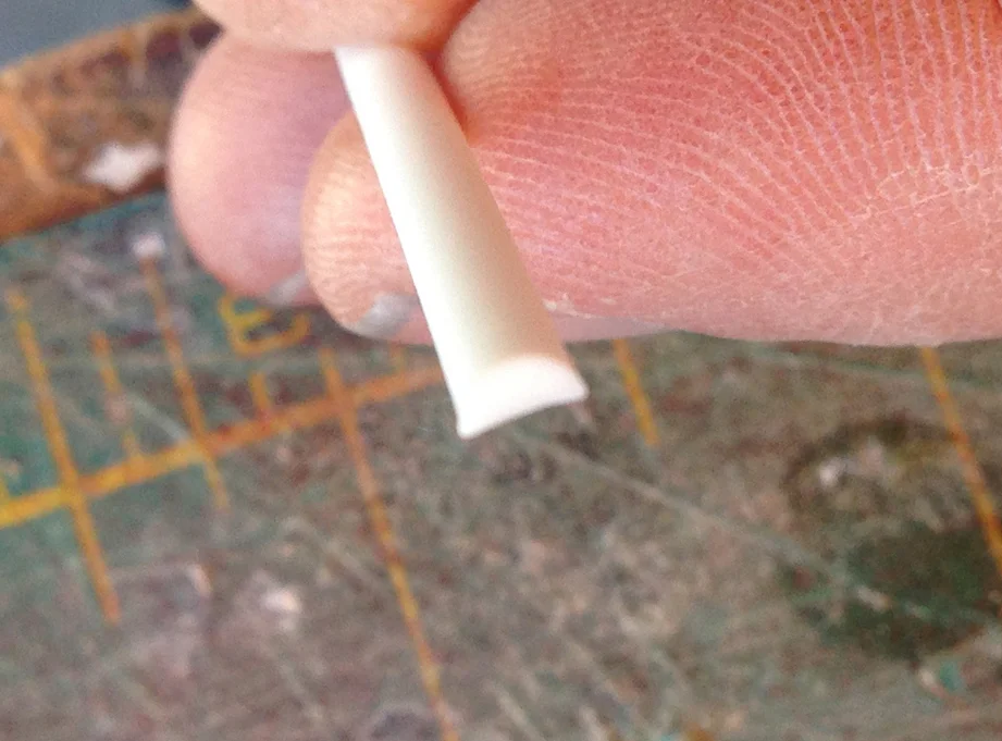I bought half round styrene strips to apply to the raised bands. For some reason the flat edge of the half round strip is not actually flat. This causes problems when you try to glue it down.