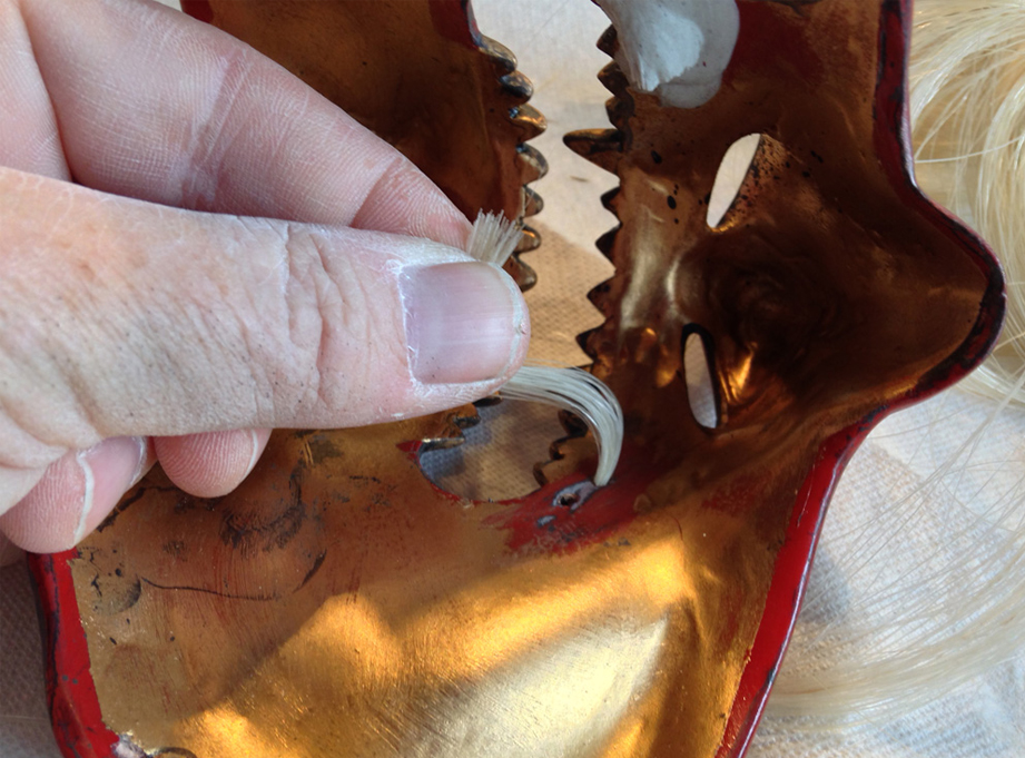 The hair was pulled inside the mask. Dig the antique gold inside!