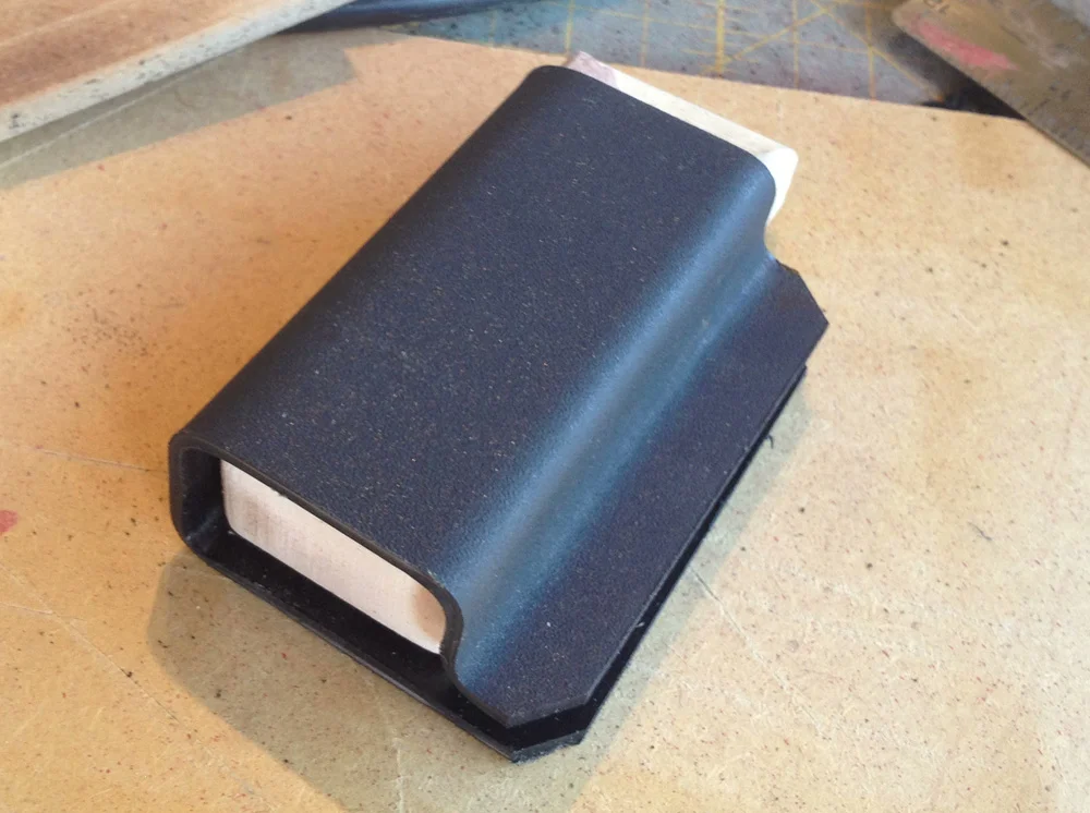 The bottom is bent at the edges to keep the magazine from slipping down too far.