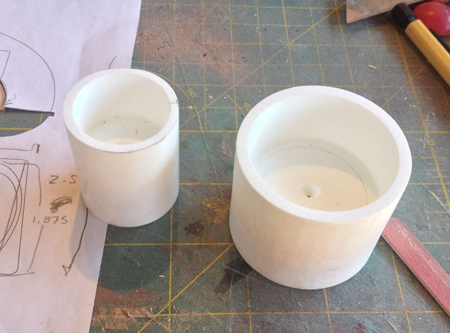  I cast a plug of resin for each size wheel, then drilled out each side with forstner bits to make hollow wheel rims with a flat wall in the middle. 