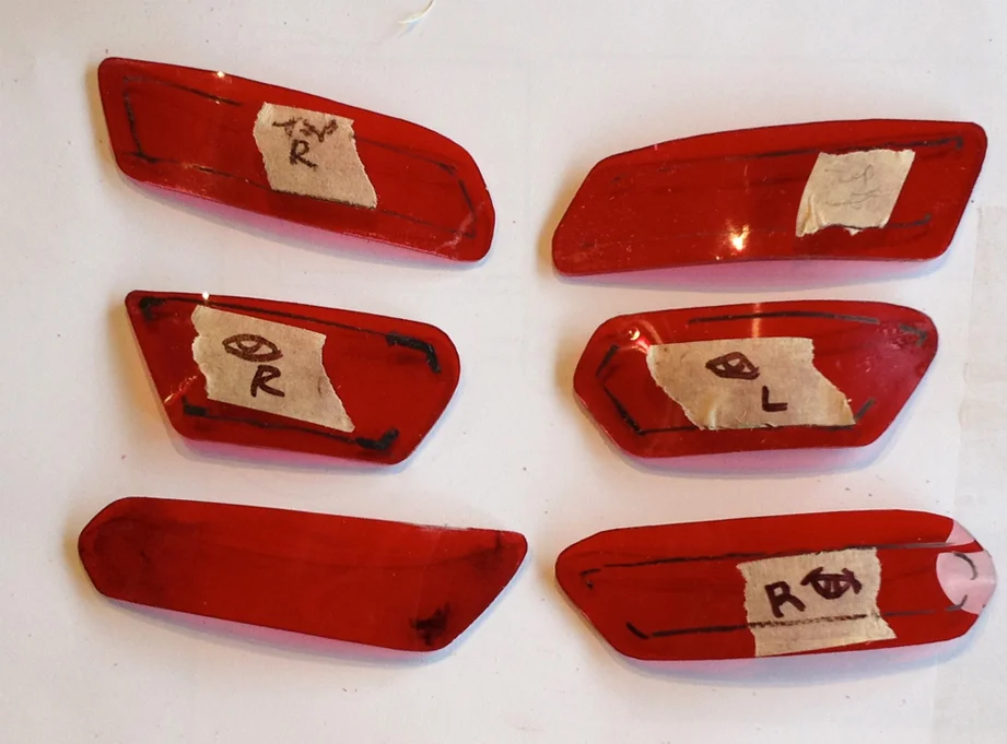 To fit the lenses, I cut some 1/8″ red acrylic to roughly the size, softened it with a heat gun and pressed them to fit from the inside of the holes. Since the fit was specific to each hole, I marked their identity with a black China Marker (which is a wax pencil).