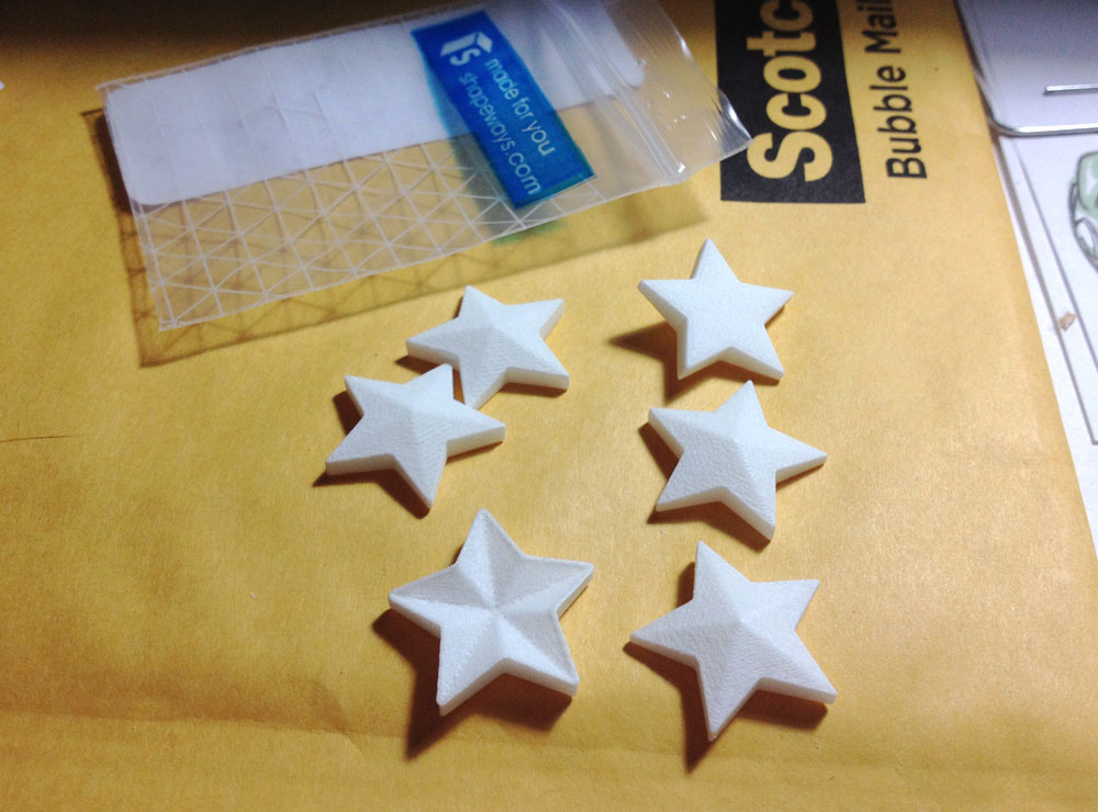  About three weeks after I ordered them, the 3D printed stars arrived from Shapeways. I also had them print a stamp for the holes that was 1mm wider than the stars. 