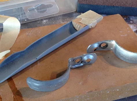 The bottom of the gun features a presumably movable lever which I cut from a piece of irrigation tubing. To attach it to the gun, I cut a piece of wood to strengthen the connection and hold a pair of metal brackets.
