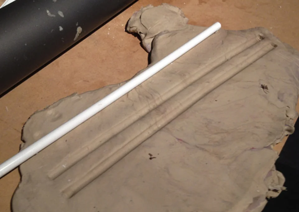 I needed very thick half round piping for the edges of the vambrace, well beyond what’s commercially available. I took a plastic tube of the proper diameter and pressed it into some clay for a temporary mold.