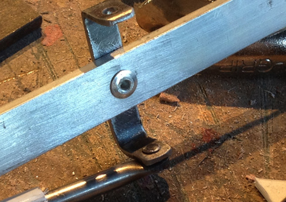  To make the cocking arm on the vambrace, I bent a 1/8" thick bar of aluminum and added a strip of steel with a pop rivet for the side pistons to attach. 