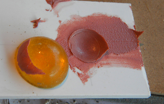  To make the dish-like recess for the muzzle (where the laser beam comes out), I cut a hole in the front plate, globbed in some Bondo and pressed it into a dish with a spare acrylic gem. 