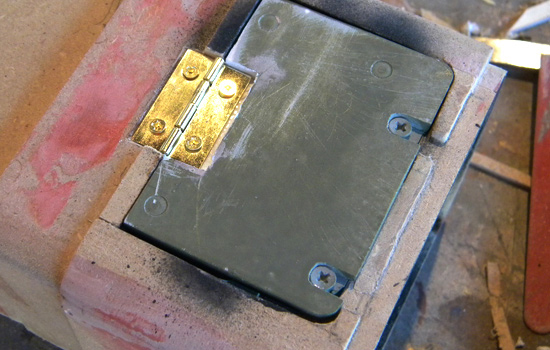  I attached the battery door with a small brass hinge. I cut a recess in the door and end cap to hide the hinge. 