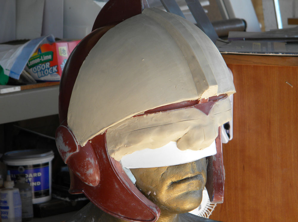  To make the visor, I placed the helmet master back on my plaster head and sculpted the visor lens as smoothly as I could. 