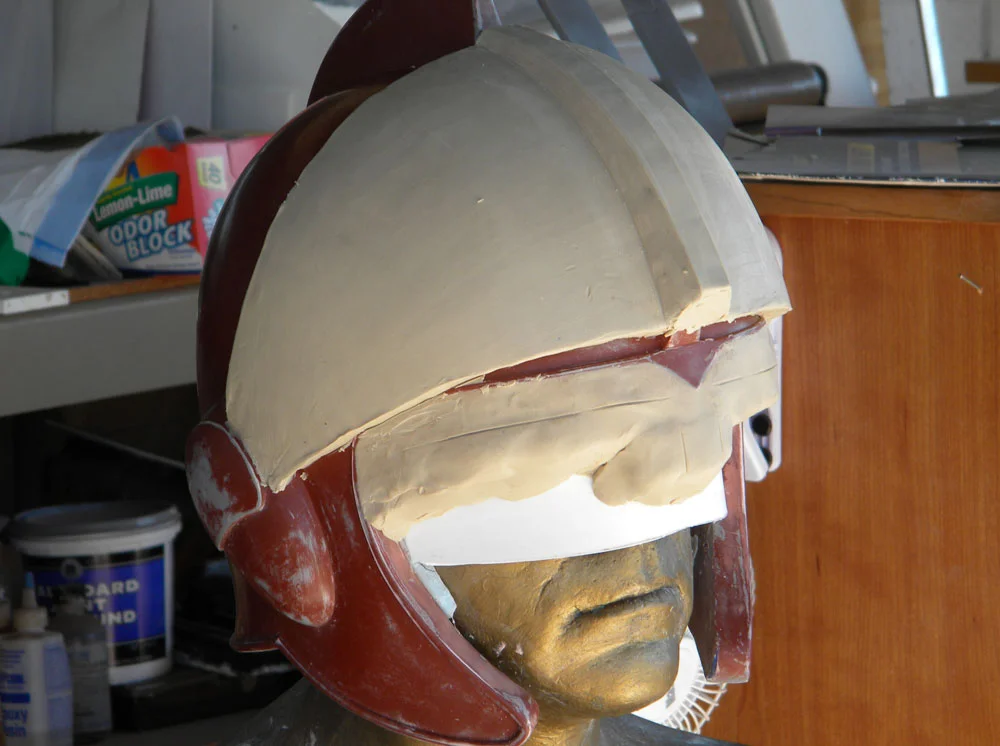 To make the visor, I placed the helmet master back on my plaster head and sculpted the visor lens as smoothly as I could.