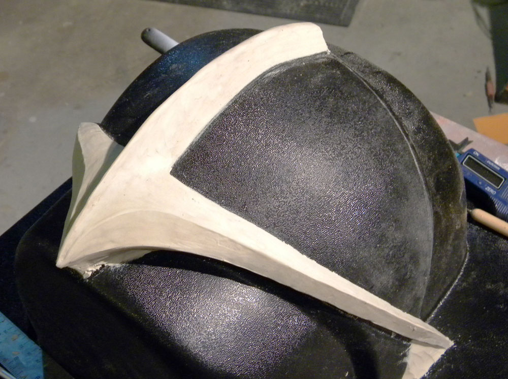 When I had the clear visor pulled, I also had them make an ABS copy that I could use as a sculpting form for the visor trim. I used clay to shape the visor and got it as smooth as I could (which isn’t very smooth, as you can see) 