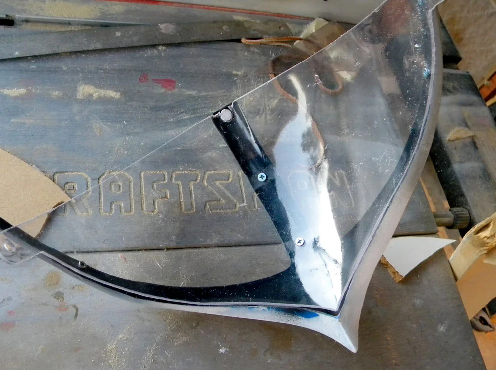 Many glues will haze or melt clear plastics, so I secured the visor to the trim with screws. I glued in rare earth magnets at the top to allow the visor to stay up.