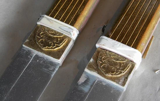 The cast resin grip collars and decorative blade bases glued to each sword.