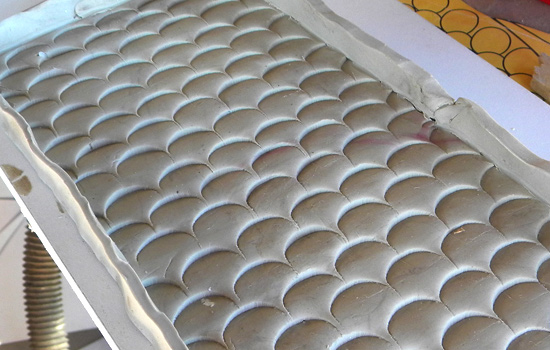 I rolled out a long sheet of clay and stamped scales into the surface.