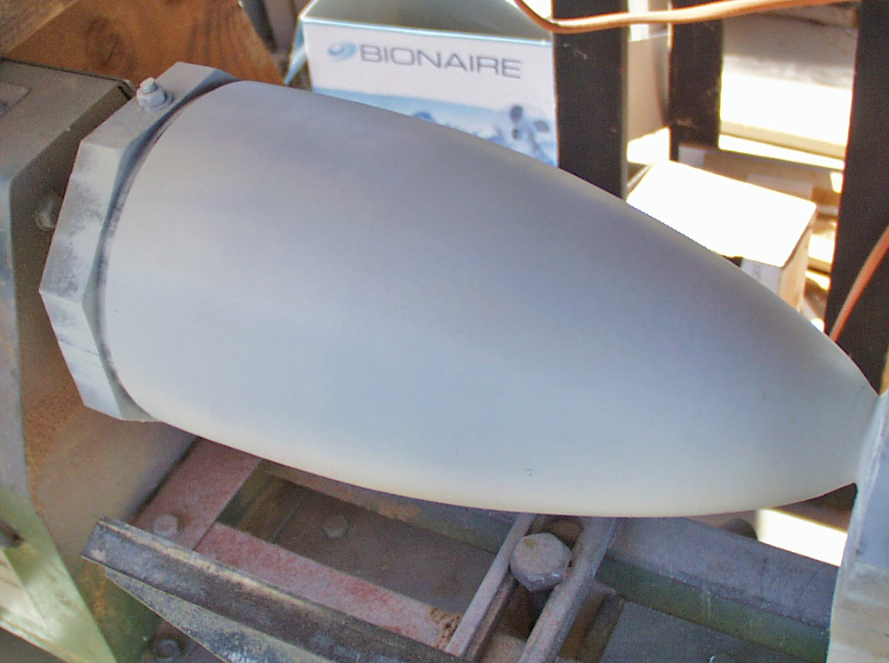  After much putty and sanding, the nose cone is ready to remove from the lathe. The MDF pieces at the ends were removed and the rounded tip of the cone was shaped by hand. 