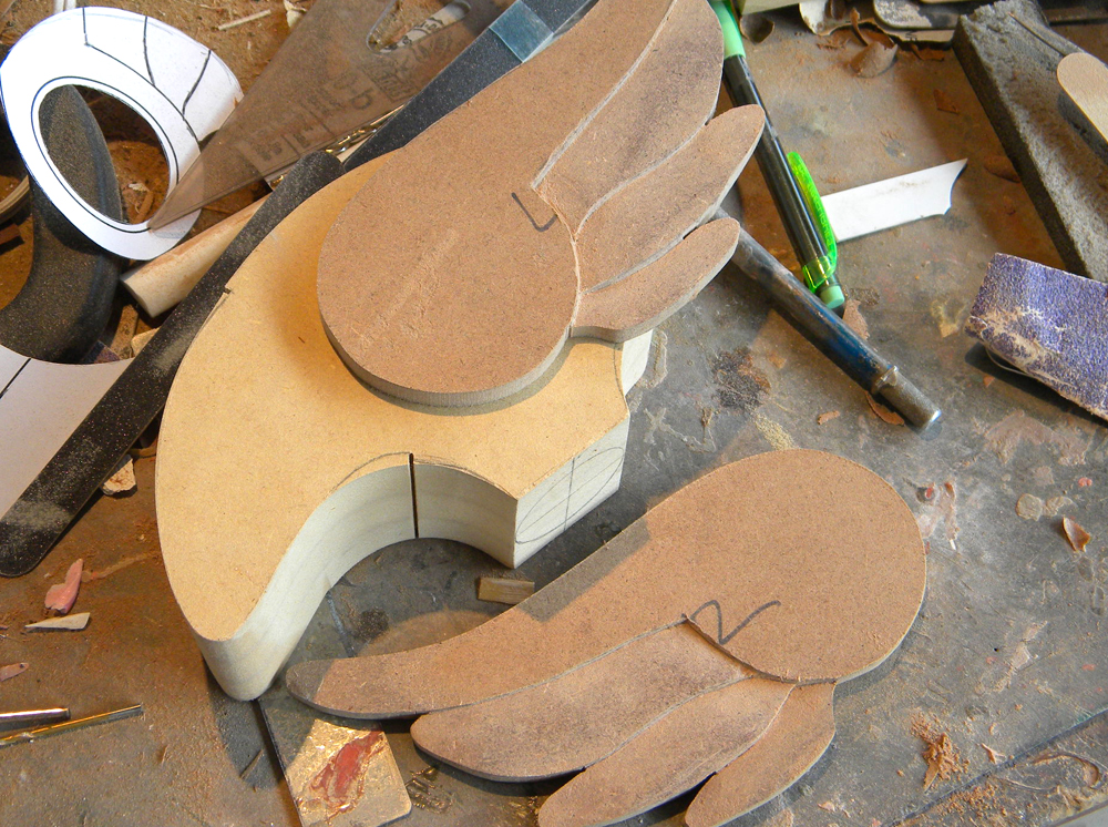 I made the wings from 1/4″ MDF and carved out the layers of feathers with Dremel, chisels and blades.