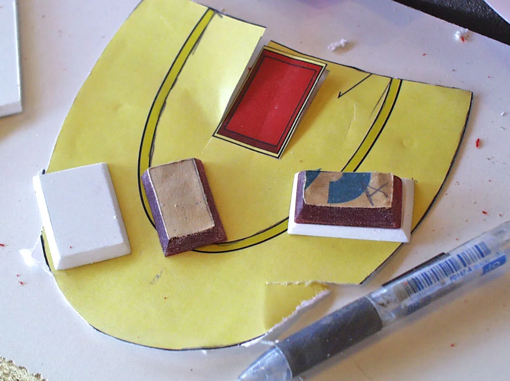 The hilt gems were cut from 1/4″ red acrylic. The base was cut from thick styrene.
