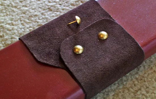 I glued the leather to the scabbard and used upholstery tacks to simulate rivets. I trimmed the nail so that it only went 1/8″ into the scabbard surface.