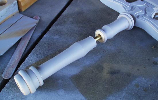 The grip was lathed from a pine dowel. I cut it in two so that I could drill out a channel for the steel rod.