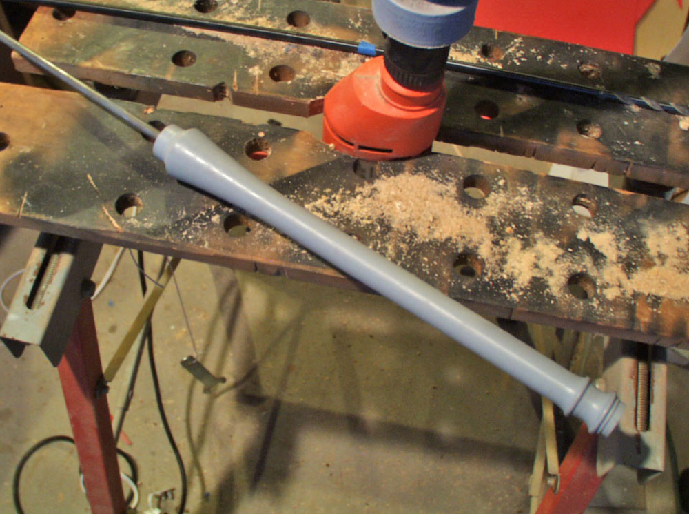 The handle was shaped on the lathe from Bass wood. I used a long drill bit to core out the center to allow the 5/16″ steel rod.