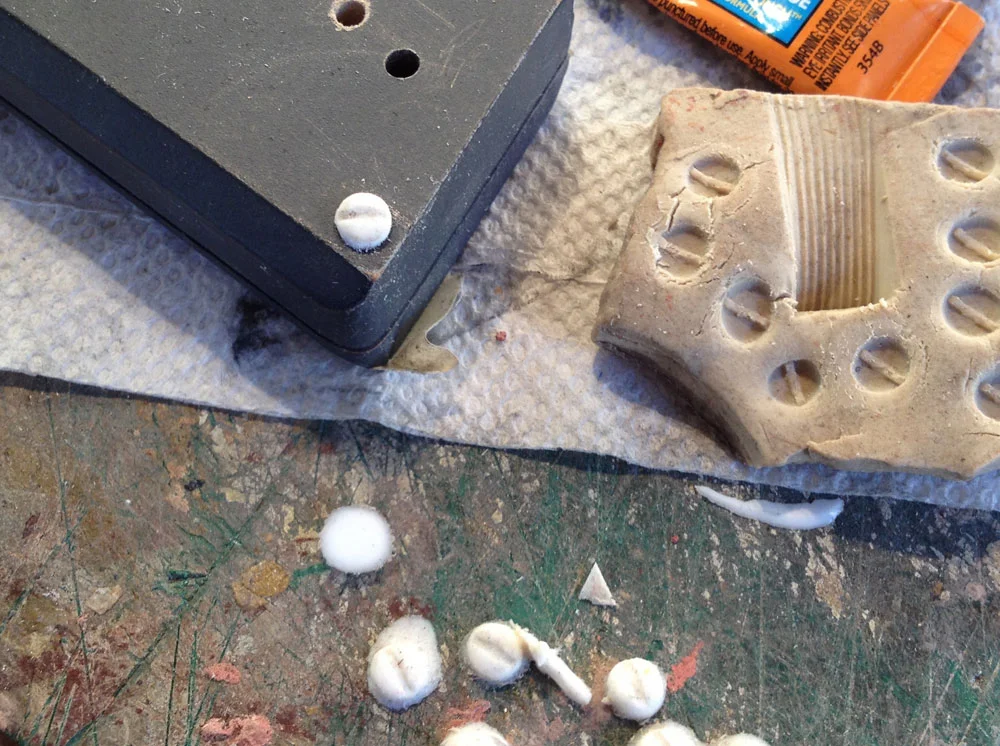 I needed round headed screws for the base of the grip and OF COURSE there was only one in my hardware bins. I guess I was too lazy to go to the hardware store to buy three more so I made a quick mold of the one in clay and dumped resin into it to make plastic copies.