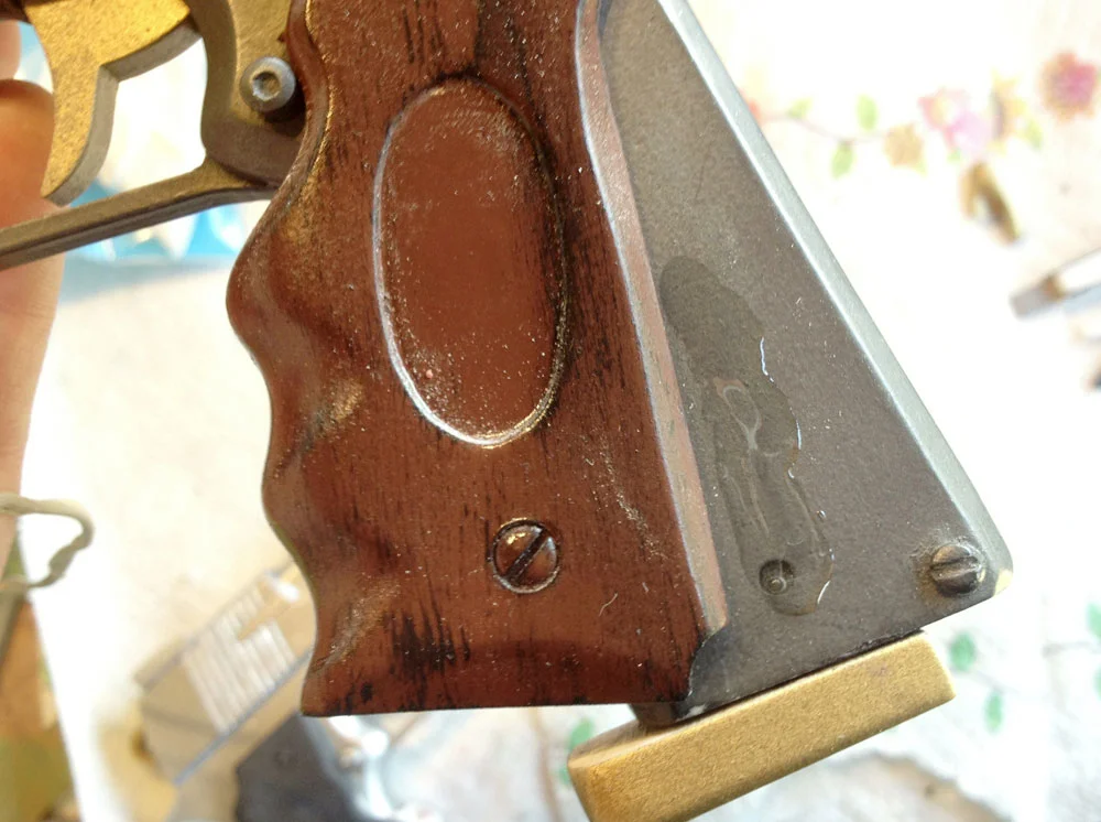 The grips were painted with a base coat brown and then dry brushed wood grain was added. Once dry, I glued them to the pistols.