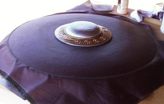 The cover completely glued down. The vinyl was stretchy enough not to crease or wrinkle. After the glue had time to set, I used an xacto knife and trimmed off the excess.