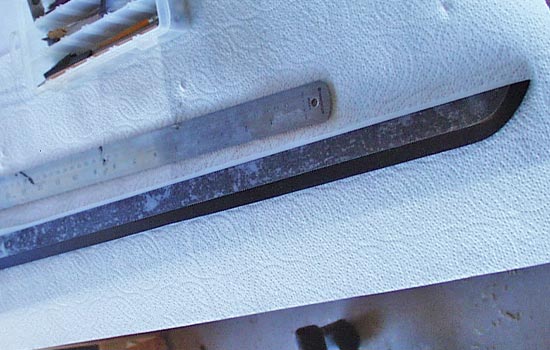 The blade was painted with a Krylon semi-gloss black. The black was then masked off to expose the edge so that it could be painted silver.